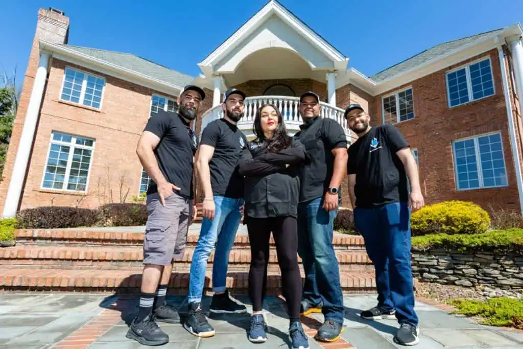 exceptional glass company posing outside of large house.